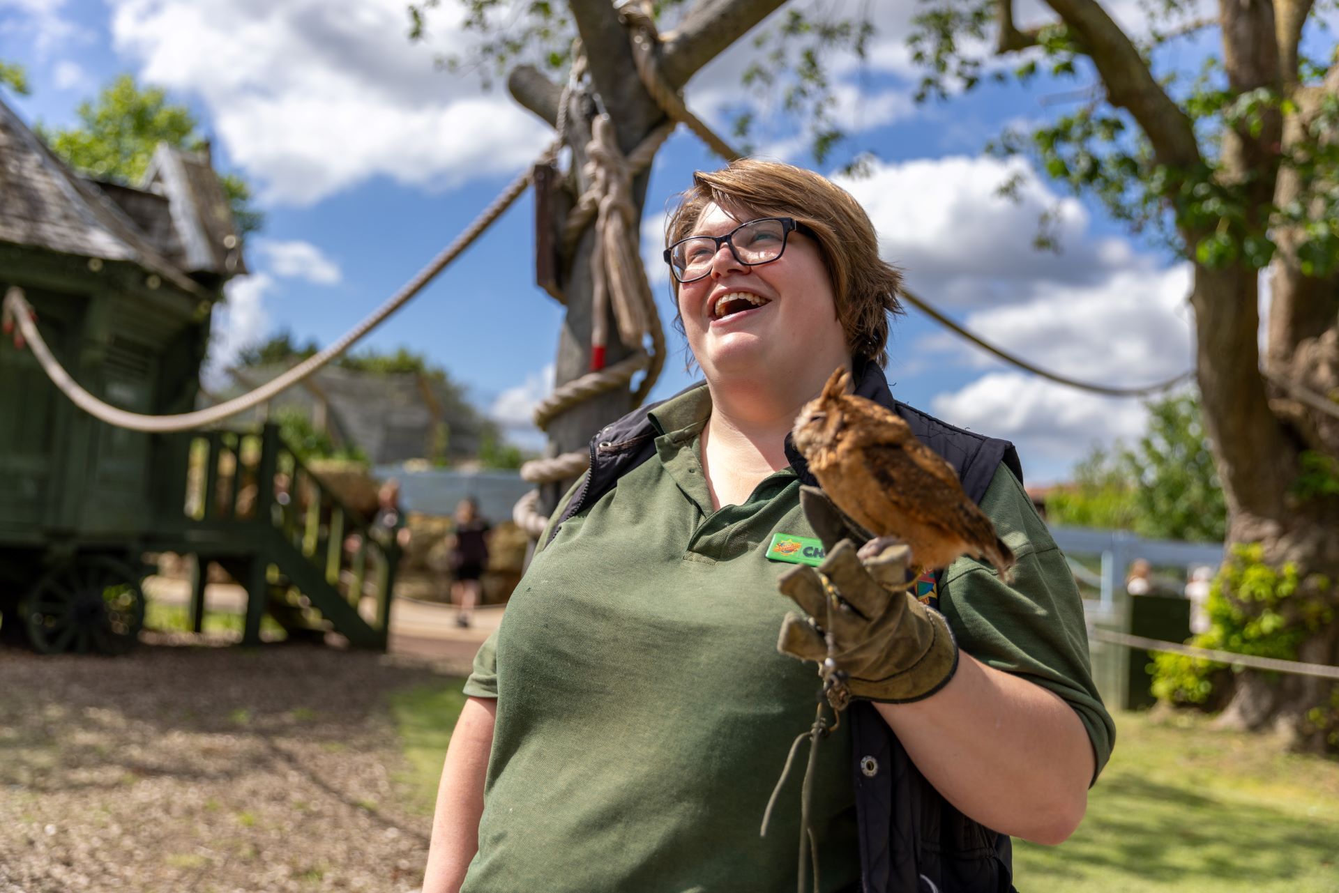 Zoo staff member smiling while holding an owl 