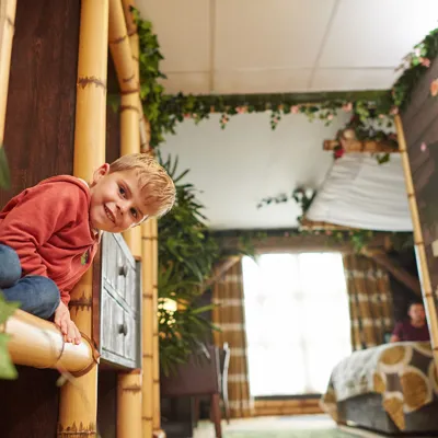 Child peeking round a corner inside a Penguin themed room