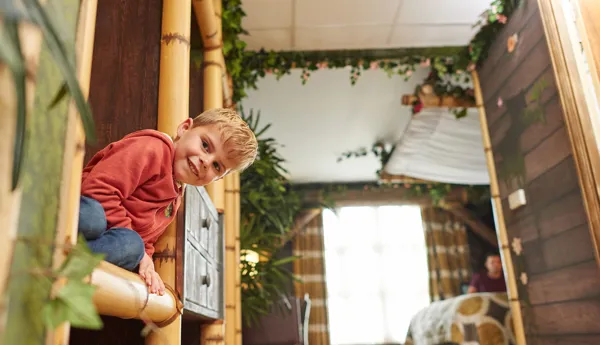 Child peeking round a corner inside a Penguin themed room