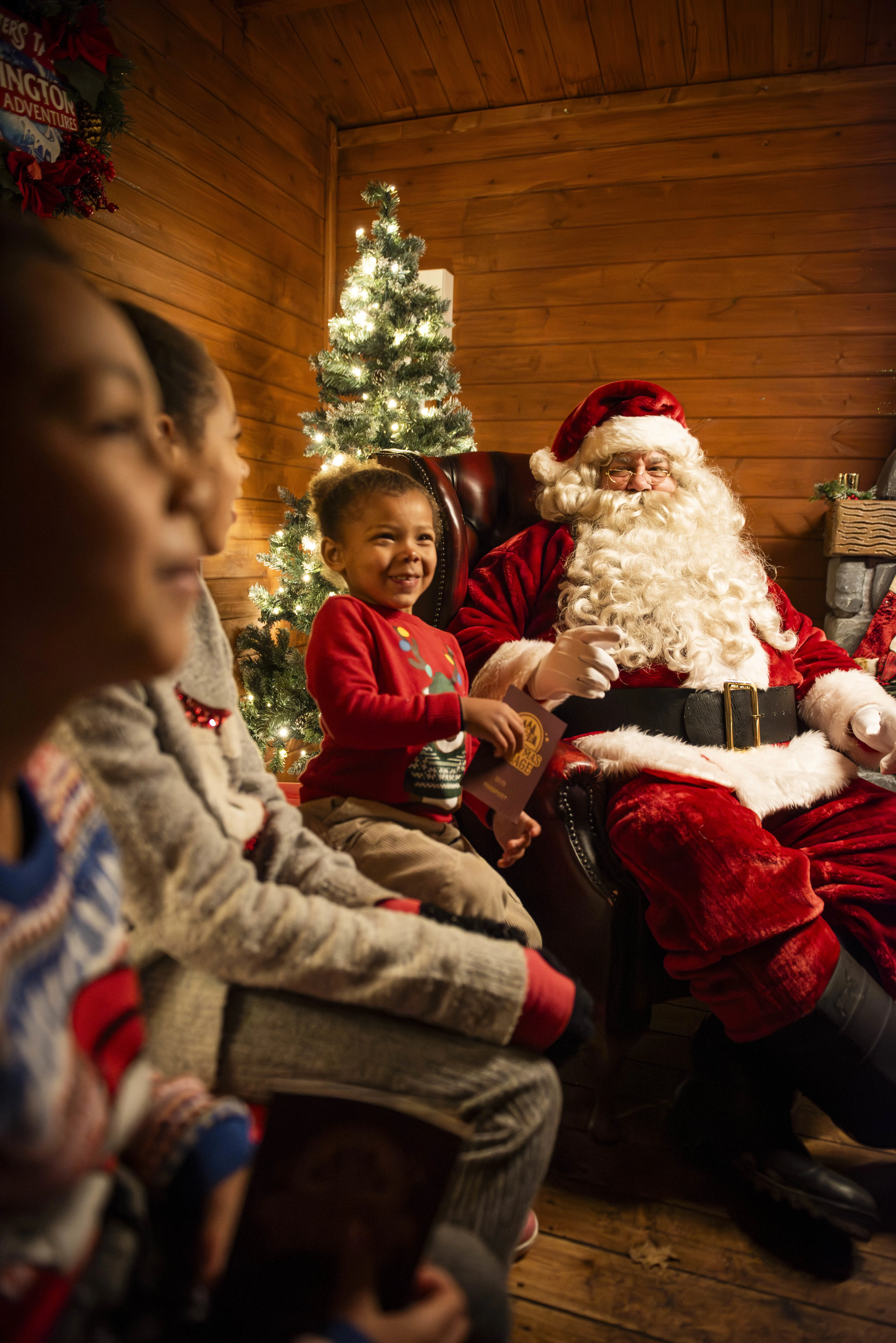 Father Christmas meeting children in his grotto at Chessington Winter's Tail