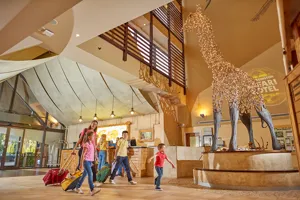 Families walking though the lobby of the Chessington Safari Hotel with giraffe statue