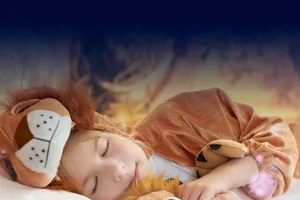 Child sleeping in lion costume in a hotel room at Chessington